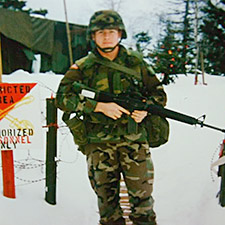 Brett Conklin standing guard over a Christmas village at an SFOR base in Bosnia.
